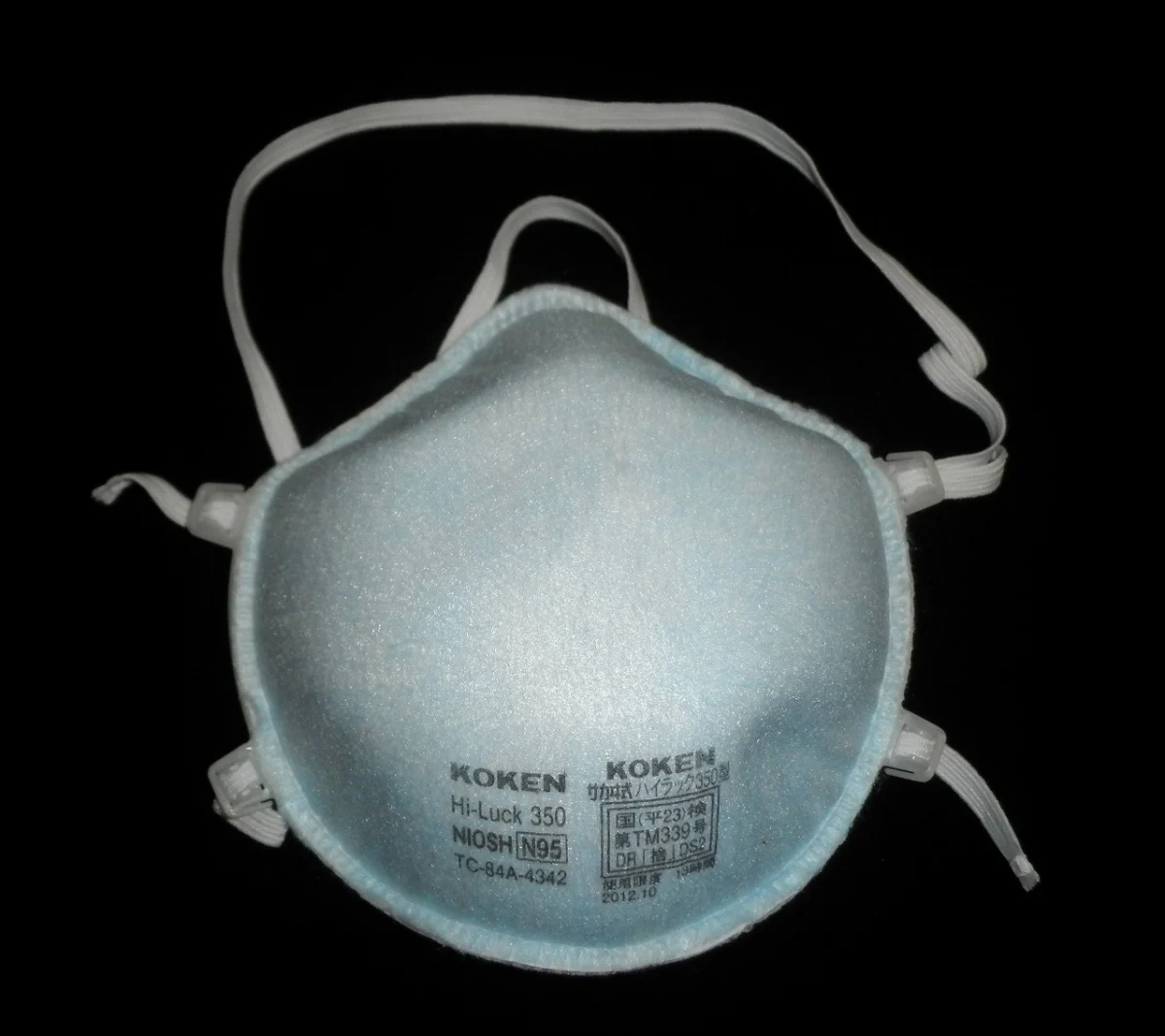 An N95 respirator mask with two head straps and a nose clip